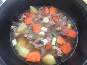 加入牛肉跟新鲜的葱段，盖上锅盖中小火慢慢炖
