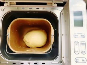 首先来和面，将除黄油以外的所有食材放入面包桶里，用筷子搅拌至无干粉状态，然后启动面包机“和面”档，面团揉至光滑的时候加入室温软化的黄油，继续揉至完全阶段，这时面团的状态细腻有光泽，而且有非常好的韧性。