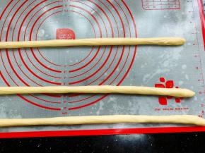 然后将面团从中间往两头搓长，搓成长度为50-60cm左右的长条形。