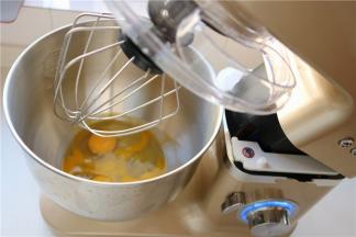 先来制作杯子蛋糕，把鸡蛋打散，和白砂糖，蜂蜜一起放入打蛋盆里。打蛋盆坐在40度左右的热水里，不停的搅拌蛋液，使蛋液整体达到温热的程度后拿出来，安装在厨师机底座上。开7档，大约打发时间需要4分钟。