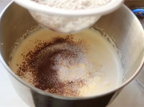 可可粉和低筋粉混合在一起过筛，加入一半到蛋糕糊里。用刮刀兜底翻拌，大约十几二十下，左手要不停的转动打蛋盆，保证每一个地方都拌到。