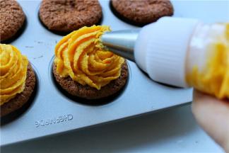 把南瓜乳酪霜挤到杯子蛋糕上面，收口处轻轻提起，再把做好的帽子直接压在收口处即可，角度看自己喜欢咯。