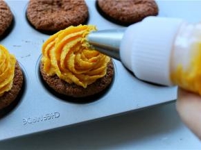 把南瓜乳酪霜挤到杯子蛋糕上面，收口处轻轻提起，再把做好的帽子直接压在收口处即可，角度看自己喜欢咯。