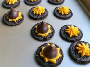 先来做帽子。奥利奥分开，夹馅可以不去，正面向上，挤上一点南瓜乳酪霜，放上一个好时巧克力。帽子就做好了。