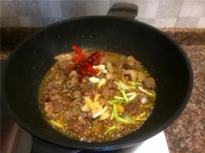 放入泡椒、泡姜、花椒、大蒜和葱头翻炒片刻。