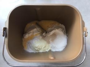 面包桶内加入高筋面粉，奶粉，全蛋液，细砂糖跟酵母 