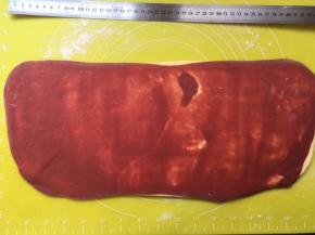 撒点干粉，将面片擀成40厘米长，15厘米宽的梯形，擀成梯形这样剪裁后，裁下的边角比较少一些 