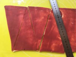 再用钢尺在上边每5厘米用刀压出一个点，下边对齐也是每5厘米用刀压出标记 ，之后按照标记，用刀裁成三角形 

