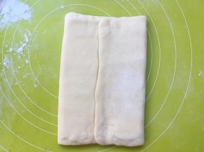 将两侧的面片折叠过来，包裹上黄油片，黄油片一定要包裹严实，免得擀的时候跑油 
