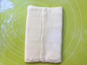 将两侧的面片折叠过来，包裹上黄油片，黄油片一定要包裹严实，免得擀的时候跑油 
