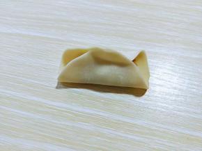 先对折，捏紧，如图。