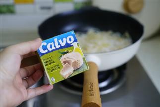 将煮好的面粉控水回至到不粘锅里，然后趁热罐头鱼头下锅。