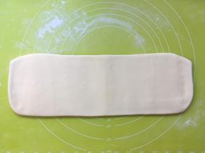 撒点干粉，再次将面片擀成长条，这次的长度大约有30厘米左右 
