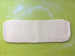 撒点干粉，再次将面片擀成长条，这次的长度大约有30厘米左右 
