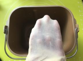 加入牛奶启动揉面程序将材料揉成面团，揉好的面团切下一小块可以撑出厚一点的手套膜 