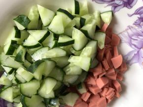 再把剩下的黄瓜切成小丁，火腿肠也切小丁备用