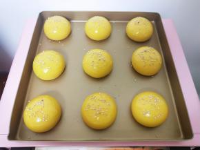 看生胚明显变大，轻按迅速弹起，拿起很轻盈了，取出，预热烤箱180度5分钟以上，同时面包胚刷全蛋液，撒芝麻。