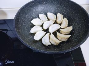 做煎饺喽～包好的饺子依次摆放在不粘锅中。
