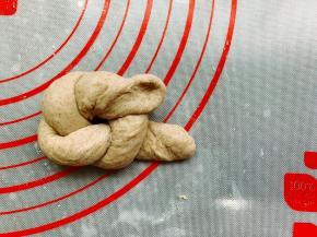 将长的一端塞入结中，两端相接，捏紧压在底部。