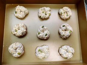 在面团表面刷上一层水，然后沾上一层果仁，排入烤盘中，并隔开一定的距离摆放，放在温度36度湿度75%的温暖环境中进行最后发酵。