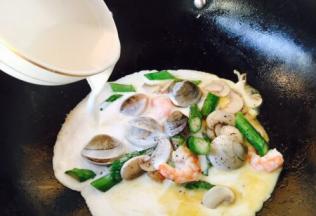 倒入步骤3备好的白汁（牛奶和淡奶油各90g），中火煮开。