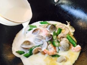 倒入步骤3备好的白汁（牛奶和淡奶油各90g），中火煮开。