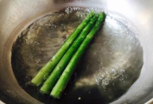 锅里放水，水里放半小勺的盐，水开后放入芦笋，芦笋断生后捞出，过凉水，切3厘米左右的段。