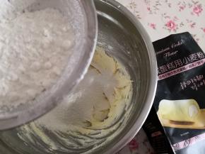 2.	鸡蛋打到酷新怡量杯里，搅散，再把全蛋液分次加入打发的黄油里，每次都要上一次完全吸收再加下一次，然后筛入低筋面粉，戴一次性手套，用手将面粉抓匀，至无干粉为止，
