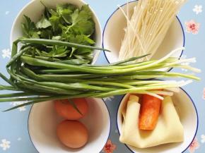 1、准备原料：豆皮、鸡蛋、小葱、金针菇、芹菜叶、胡萝卜。
