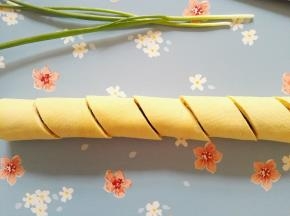 9、豆皮包裹着蛋皮和蔬菜从下往上卷起来，用刀将豆皮卷切成段即可装盘食用。