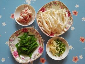 2、五花肉切条，白玉菇洗净将大一些的撕成两半，荷兰豆洗净焯水切条状，姜切丝，蒜切丝，葱切葱花。