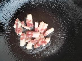 3、锅中加入食用油，加五花肉，慢慢煸出油脂。