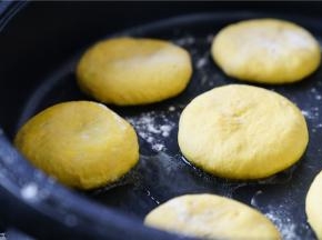 将包好的南瓜饼码放在煎烤锅里，再压至面饼微扁。