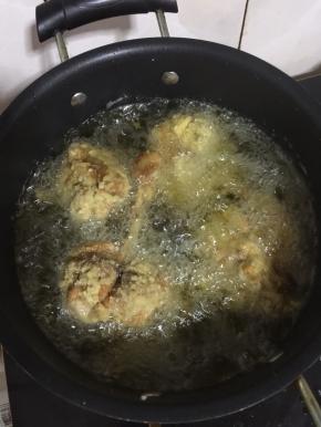 锅烧热倒入适量的油烧至七成热，放入鸡腿，大火炸至定型后，调中小火慢慢的炸。中途记得用筷子翻面儿。