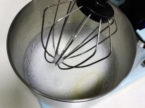 慢慢的转中速把蛋白打至细腻时，加入1/3细砂糖继续搅打。