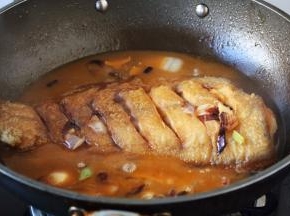 放入煎好的鲽鱼。
再放入适量的水，水的量与鱼齐平。 这时用大火炖开。