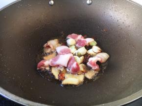 放入五花肉，翻炒至变成白色。