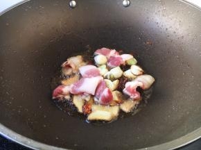 放入五花肉，翻炒至变成白色。
