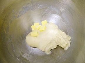 除黄油外所有面团材料按照先液体中间粉上面酵母的顺序投入厨师机，和面10分钟，揉到能拉出厚膜之后放入黄油。
