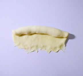 自上而下卷起，底部捏紧，收口朝下。
