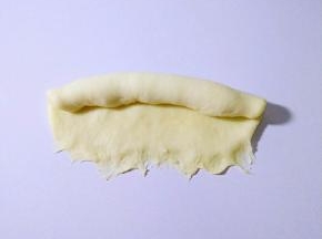 自上而下卷起，底部捏紧，收口朝下。
