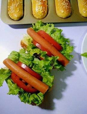 放入生菜和番茄片，再上香肠，挤上沙拉酱番茄沙司即可。