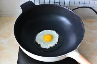 锅里加入适量的玉米油，打入一个鸡蛋，煎成太阳蛋，表面撒少许芝麻，煎好后的太阳蛋放在炒面上面，趁热食用吧，真的是太好吃了。