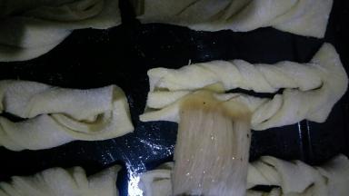 将麻叶摆入，每个中间留出少许距离，用刷子在麻叶上也刷一层玉米油