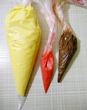 取5克面糊装入裱花袋粘少许红色素，用手搓匀，用做鼻子（这步可省略用可可面糊也行），剩下原味面糊也装入裱花袋。