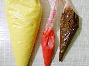 取5克面糊装入裱花袋粘少许红色素，用手搓匀，用做鼻子（这步可省略用可可面糊也行），剩下原味面糊也装入裱花袋。