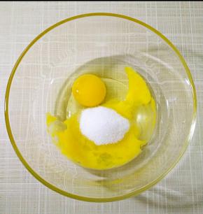 全蛋加入白砂糖，用手动打蛋器搅打均匀，无需打发。