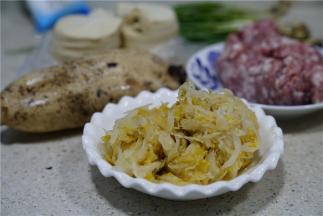 这款菜谱的用料：酸菜一份，鲜肉一分，莲藕一份，葱一份，饺子皮一份。
