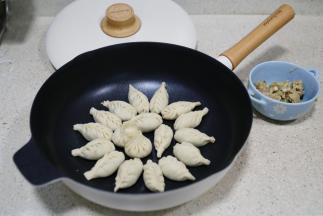 然后包在饺子皮里，包好之后码放在锅里。