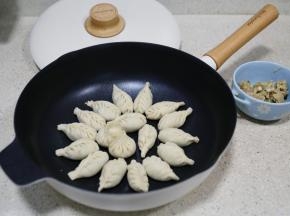 然后包在饺子皮里，包好之后码放在锅里。